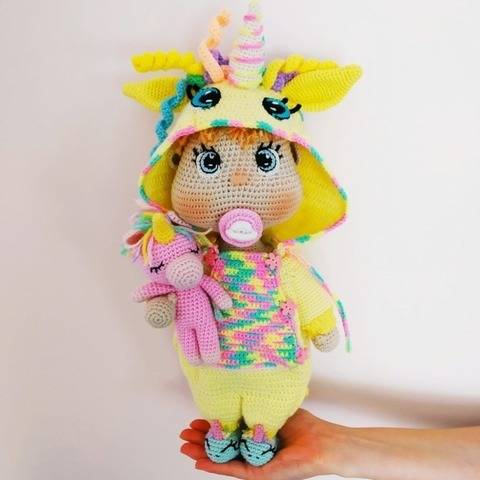 Häkelpuppe im Einhorn-Overall-Muster.